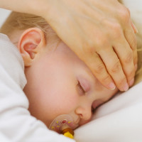 Adult hand checking the fever of a child with his hand