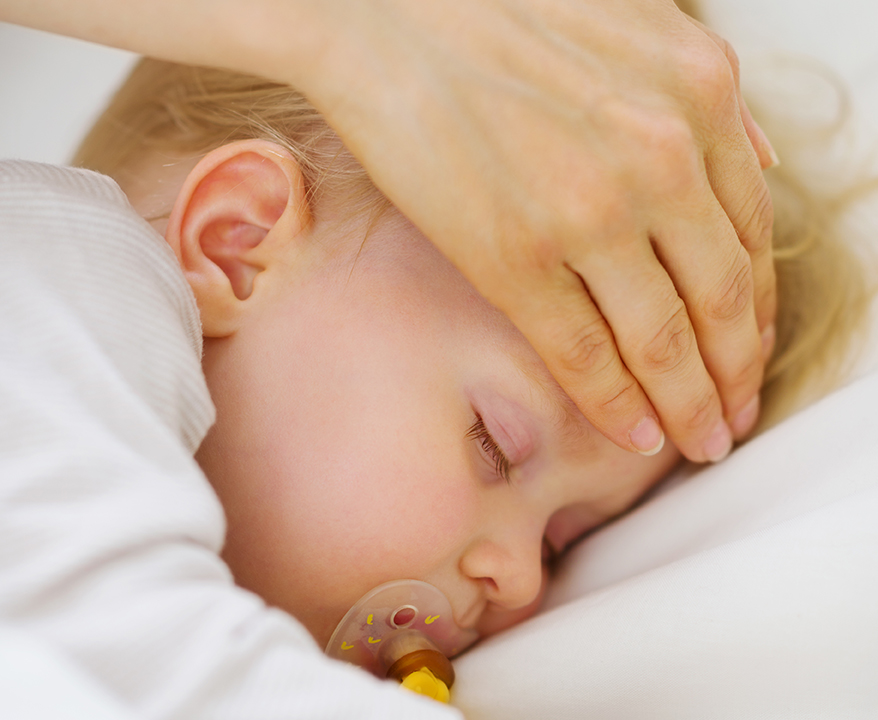 Adult hand checking the fever of a child with his hand